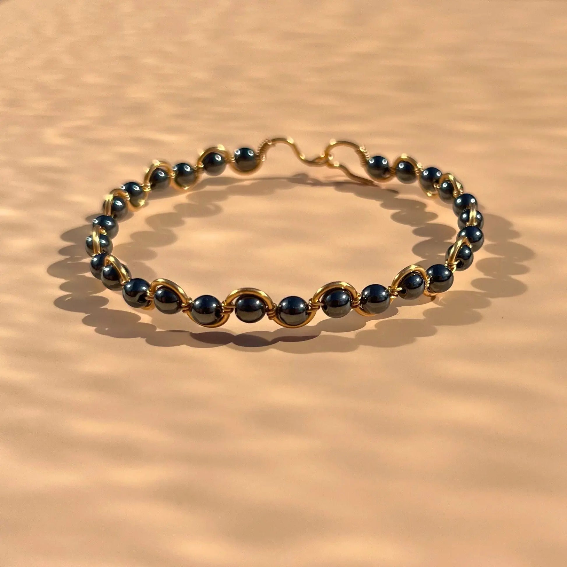 Bracelet en hématite monté sur un fil doré en zigzag