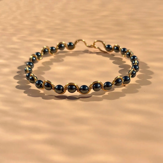Bracelet en hématite monté sur un fil doré en zigzag