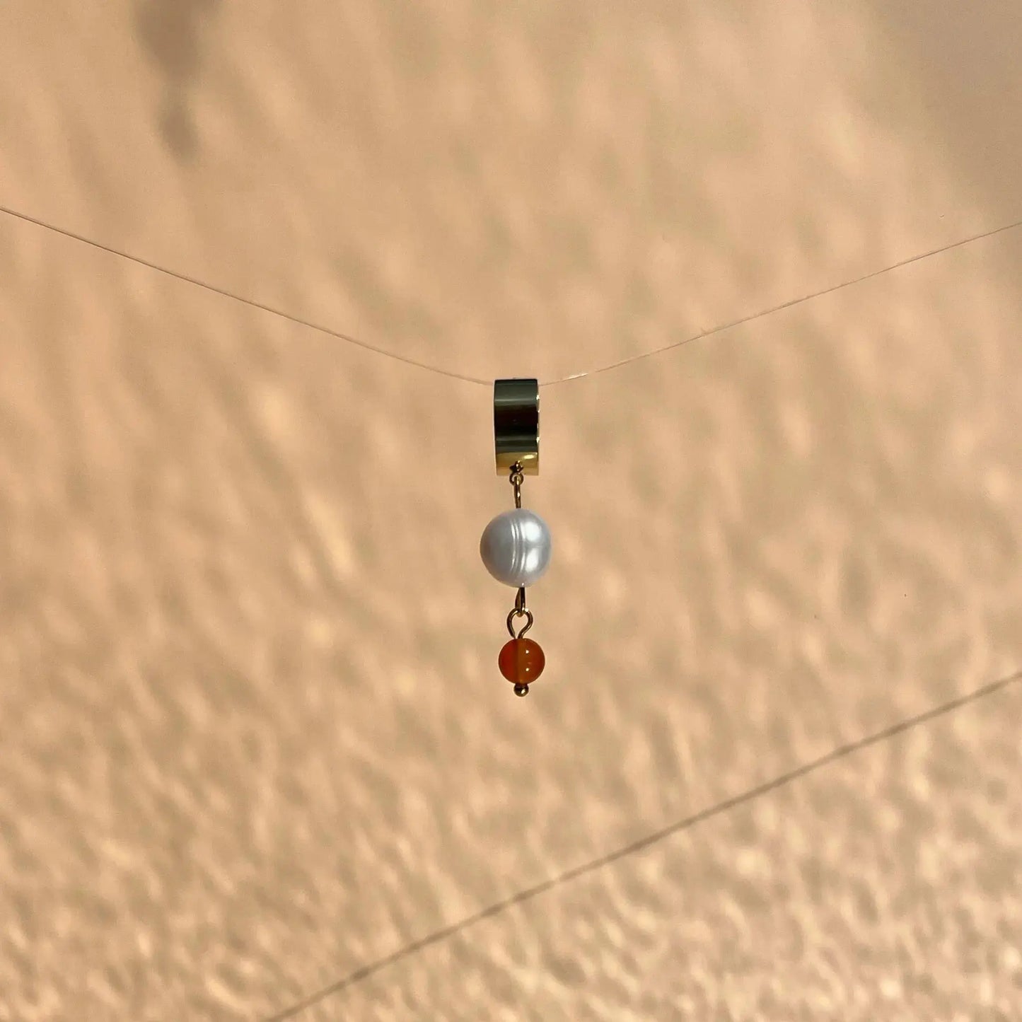 boucle d'oreille en acier inoxydable façon petite créole avec une perle de culture et une cornaline pendante
