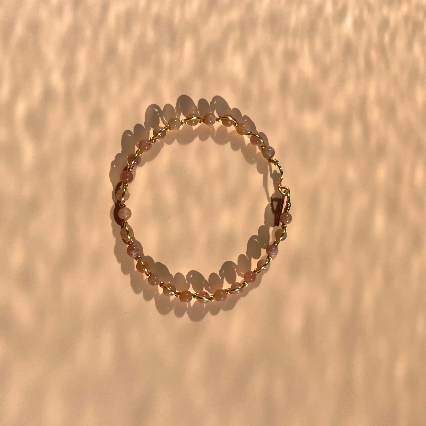 bracelet en pierre de soleil montée sur fil doré, fait main dans le sud-est de la france