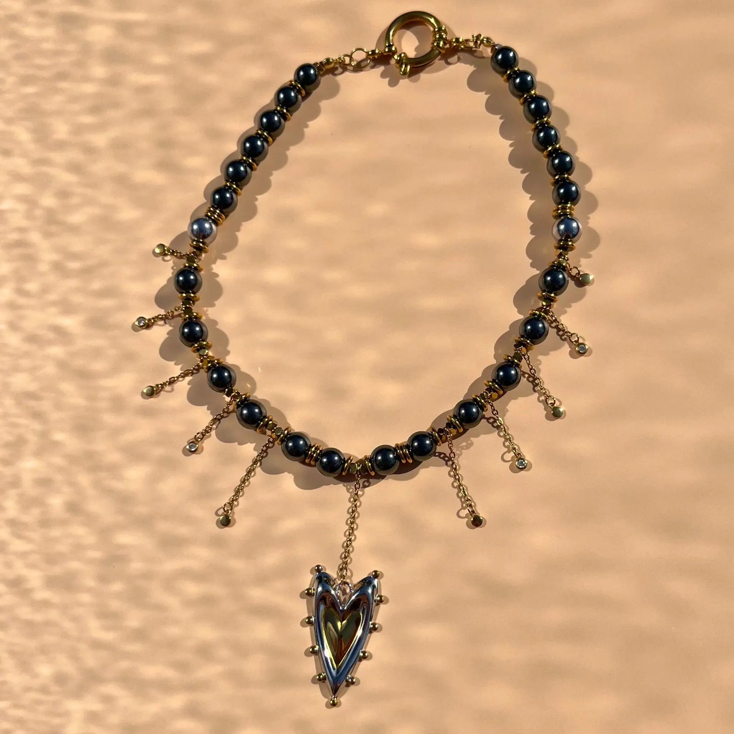 collier ras-du-cou en hématite, cascade de strass upcyclées et pendentif central coeur doré et argenté en acier inoxydable