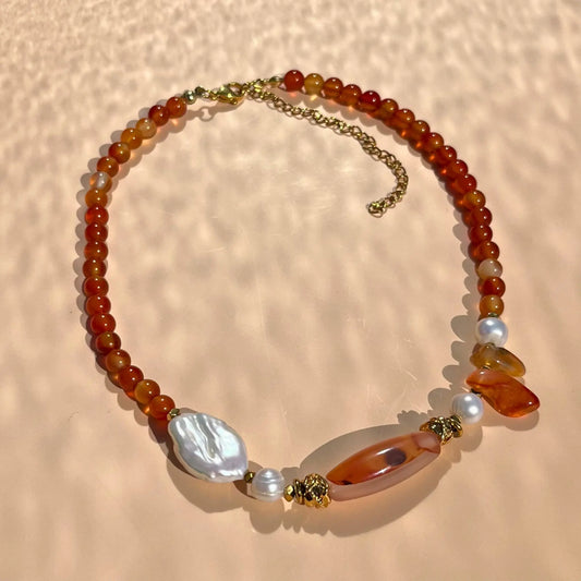 Collier en cornaline avec une agate centrale encadrée de perles de culture, hematites et perles en plaqué or. Tons dominant : orangé