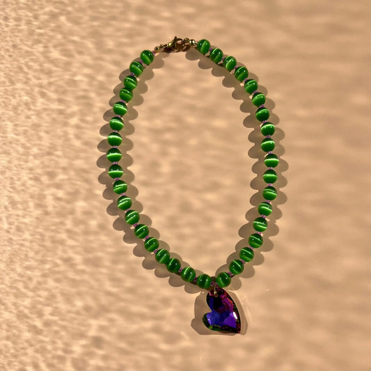 collier en perles vertes oeil de chat, perles de rocaille violettes et coeur en verre aux reflets bleu/violet