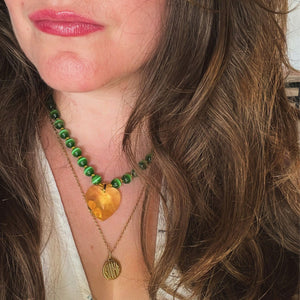 vue portée du collier Elphaba coeur jaune swarovski, oeil de chat vert et perles de rocaille, fait main