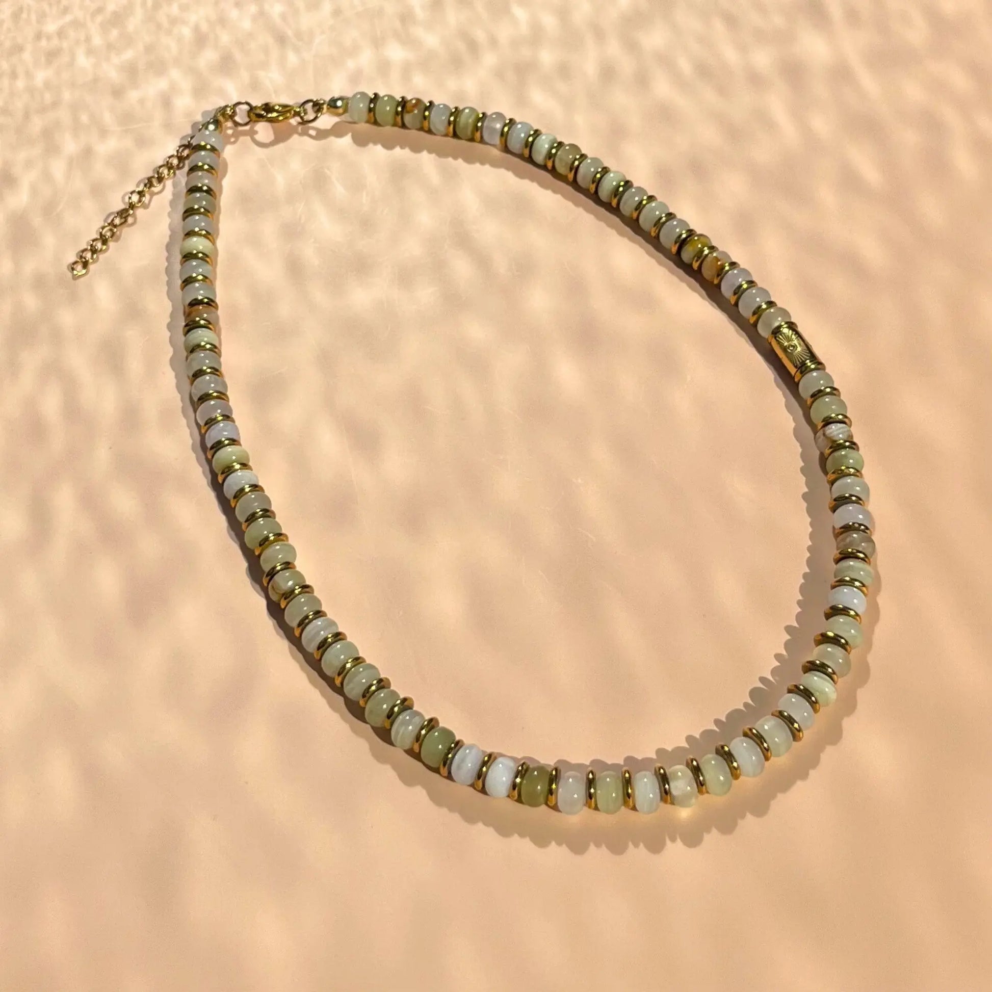 collier en perles rondelles en jade et disques en hématite, détail perle tube oeil protecteur
