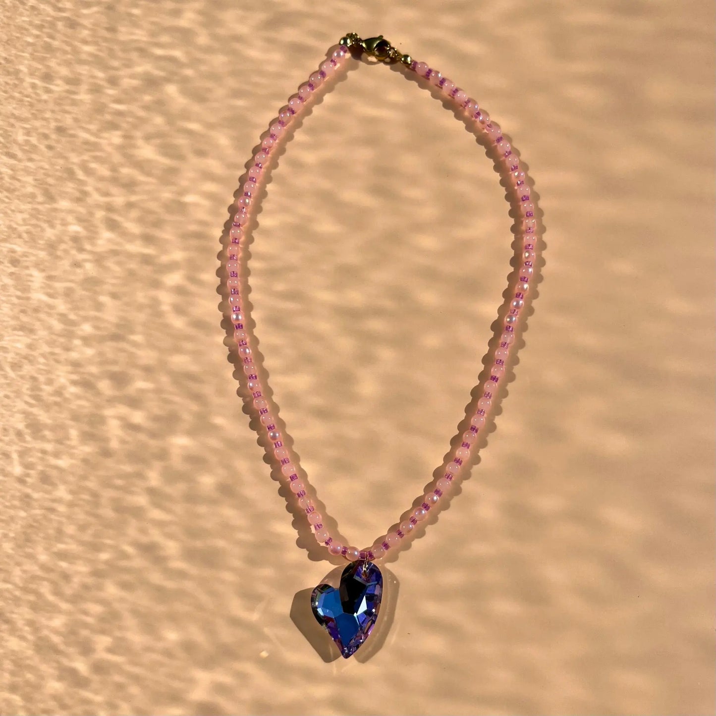Collier en perles de verre roses et perles de rocaille upcyclées roses. Coeur en verre bleu facetté