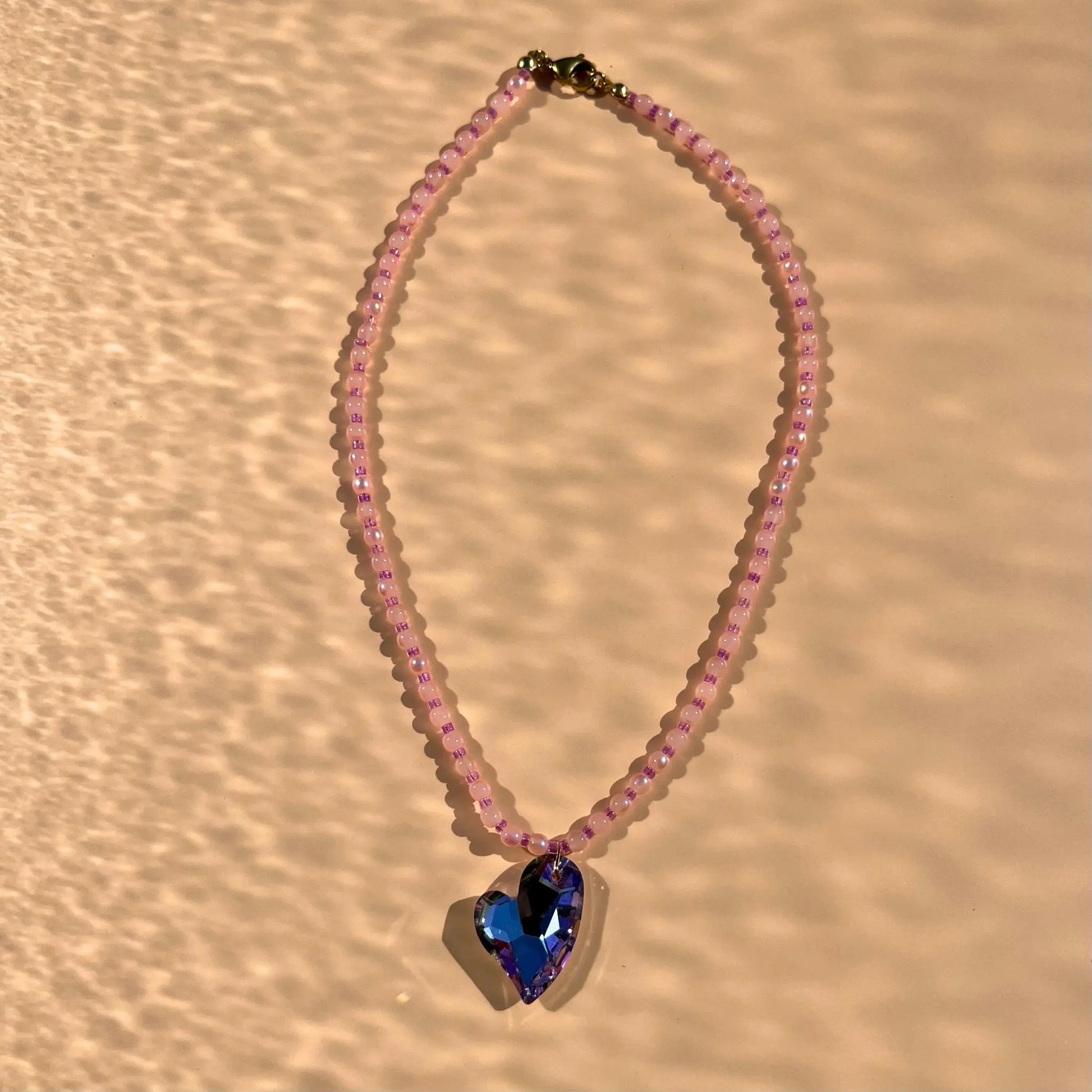 Collier en perles de verre roses et perles de rocaille upcyclées roses. Coeur en verre bleu facetté