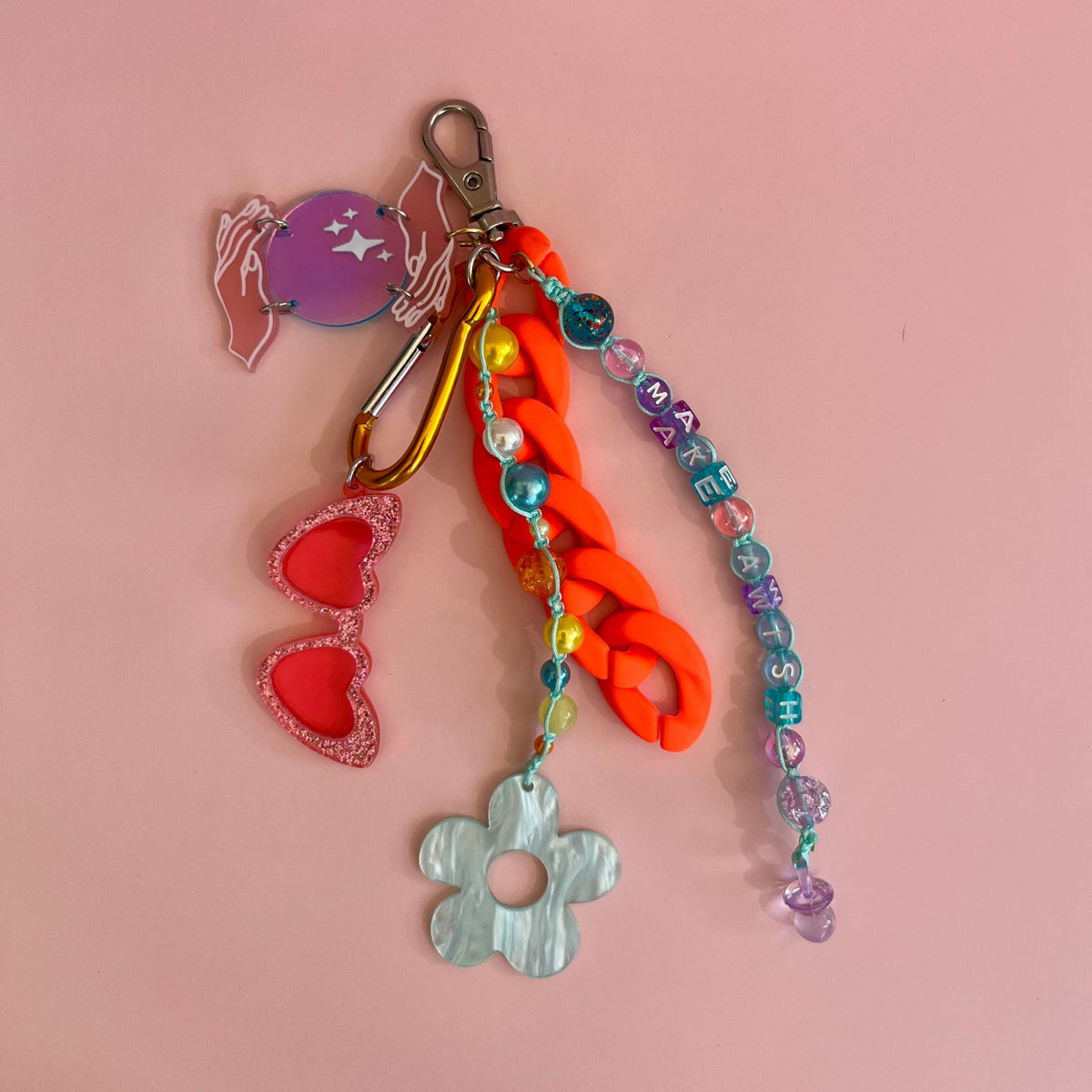 grigri coloré, lunette de soleil fleur et main étoiles en acrylique, texte : make a wish