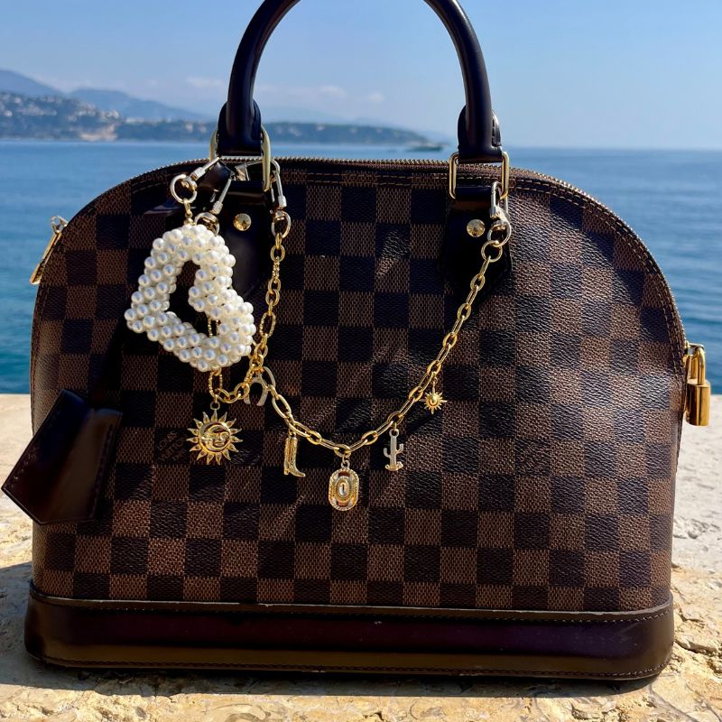 bijou de sac et grigris fait main Lodzé en forme de coeur et thème cowboy sur sac Louis Vuitton