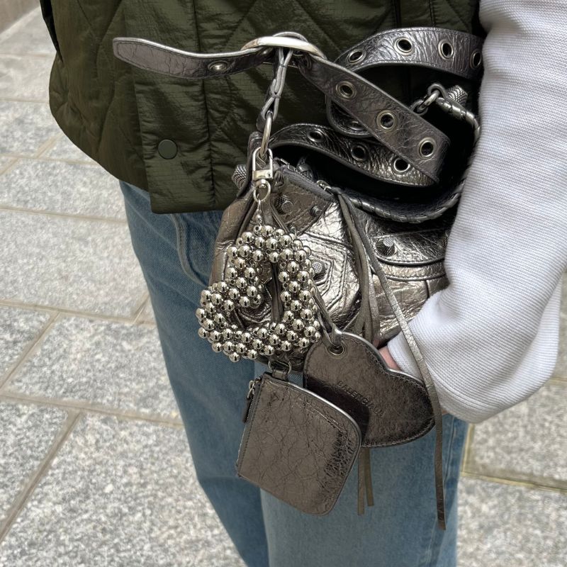 grigris en perles en forme de coeur fait main Lodzé porté sur un sac cagole de balanciaga
