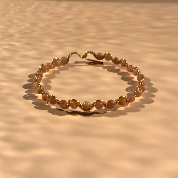 Bracelet en pierre de soleil fait main sur un fil rigide doré
