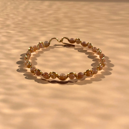 Bracelet en pierre de soleil fait main sur un fil rigide doré